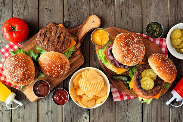 Barbacoa hamburguesa escena de la mesa. Vista superior sobre un fondo de madera oscura
. - Foto, imagen