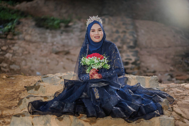 Geleneksel Malay elbisesi giyen Malezyalı sevgili gelin ve damadın düğünlerinde ışıklandırıldığı yaratıcı bir açık hava fotoğraf çekimi. - Fotoğraf, Görsel
