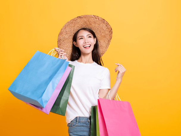 mujer joven en sombrero de verano y la celebración de bolsas de compras
 - Foto, Imagen