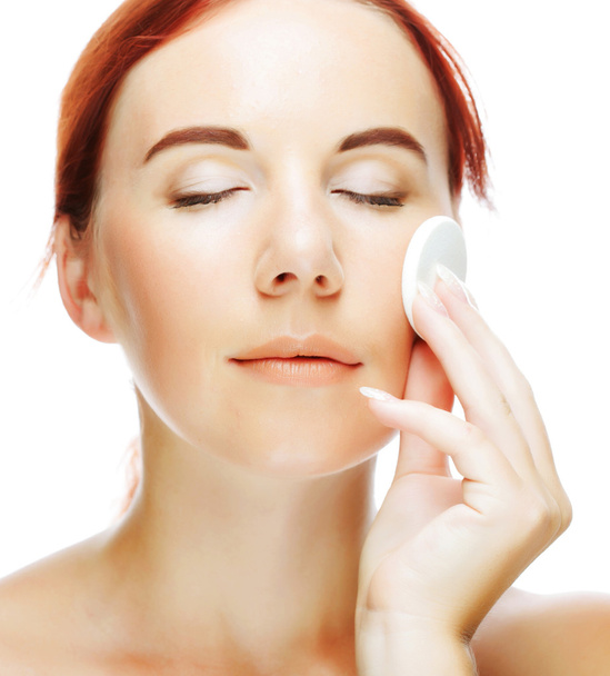 Mujer joven que aplica una crema en su cara
 - Foto, imagen
