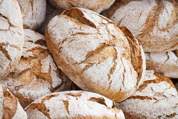 Fresh wholegrain baked loaves of rye or wheat bread - 写真・画像