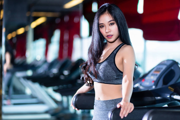 Fitness Asian women performing doing exercises training the run on treadmill in sport gym interior and health club. - Zdjęcie, obraz