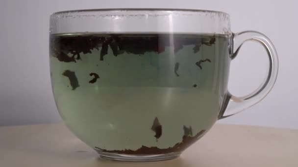 tea brewing. close-up view of a transparent glass with tea - Séquence, vidéo