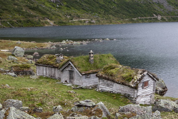 Old wooden huts on the bank of a lake in Norway Beautiful norwegian landscape - Fotoğraf, Görsel
