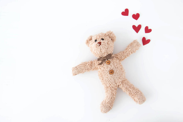 The cute little teddy bear is so happy with many hearts in valentine. - Фото, зображення