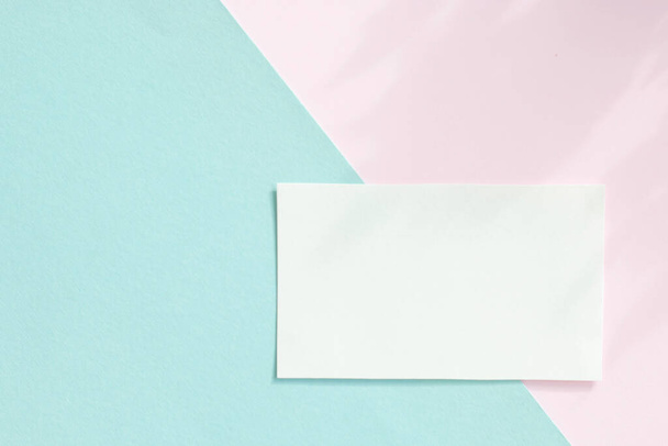 Mockup di una carta di carta bianca su sfondo pastello, Design creativo per carta da parati pastello. - Foto, immagini