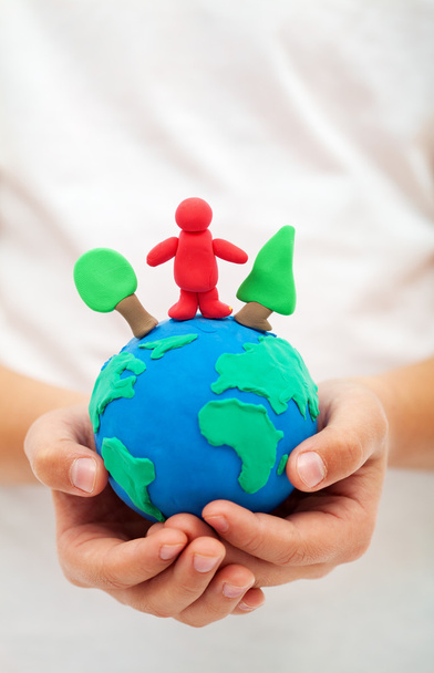 Ecology concept with clay world globe in child hand - 写真・画像