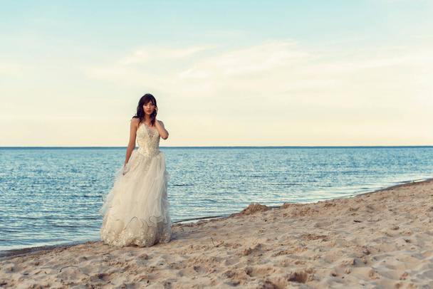 Νύφη με λευκό φόρεμα δίπλα στη θάλασσα - Φωτογραφία, εικόνα