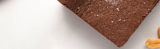 top view of delicious brownie piece on white background, panoramic shot - Fotografie, Obrázek