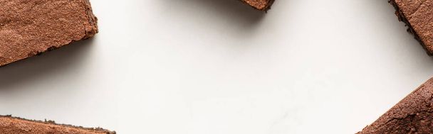 top view of delicious brownie pieces on white background, panoramic shot - Foto, imagen