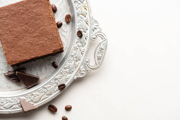 ylhäältä näkymä herkullinen brownie pala kahvipapuja ja suklaata hopea tarjotin valkoisella pohjalla - Valokuva, kuva