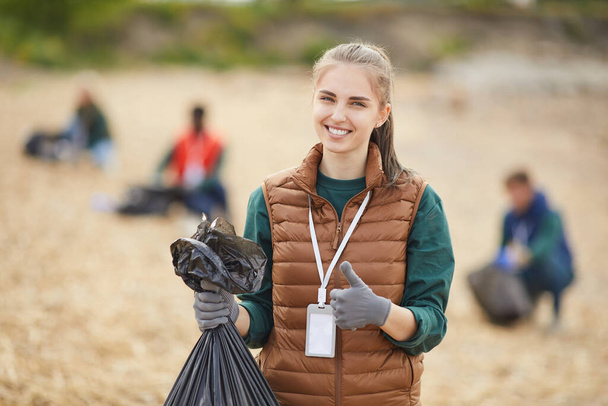 Волонтёр с мусором на открытом воздухе
 - Фото, изображение