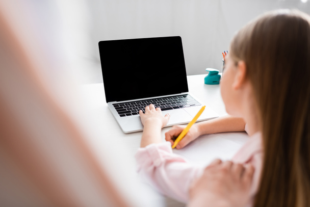 Селективный фокус матери, стоящей рядом с дочерью с помощью ноутбука и записи на ноутбуке
  - Фото, изображение