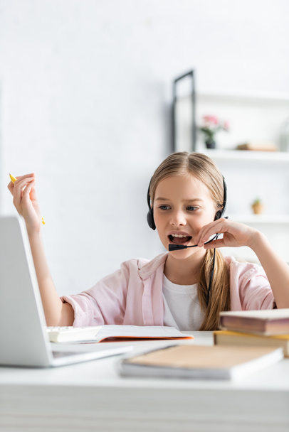 Selective focus of kid using headset during electronic learning at home  - Photo, Image