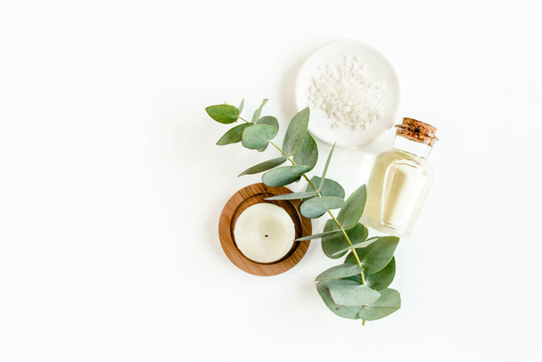Bottle of eucalyptus essential oil, eucalyptus leaves on white background. Natural Organic cosmetics products. Flat lay, top view. - Zdjęcie, obraz