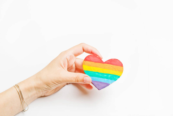 ЛГБТ-символ в руке. Сердце радужного цвета на белом фоне
 - Фото, изображение