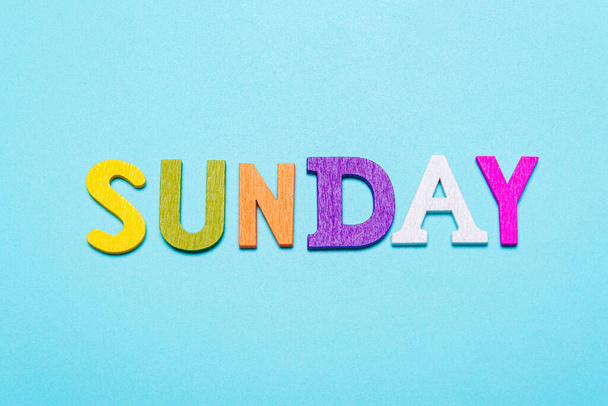 Word zondag gemaakt van kleurrijke letters op een blauwe achtergrond - Foto, afbeelding