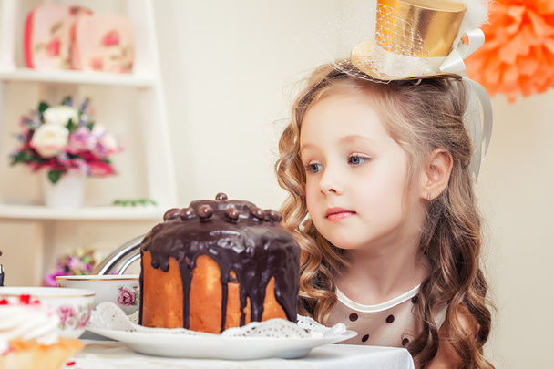 Adorable little girl looks thoughtfully at cake - Foto, Imagem