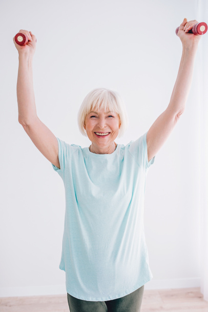 senior cheerful woman doing sports with dumbbells. Anti age, sports, healthy life style concept  - Fotografie, Obrázek