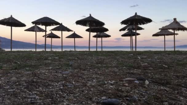 Parasols op Nees Pagases strand bij zonsondergang in Griekenland - Video