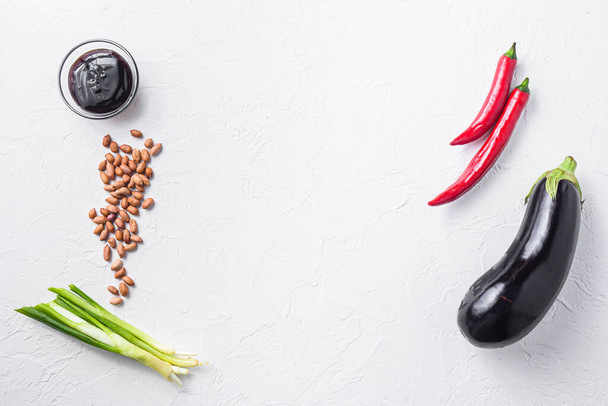 Ingredientes maduros de berenjena, para cocinar o asar chile, berenjena, salsa, nueces sobre fondo blanco
 - Foto, Imagen