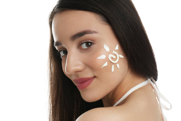 Young woman with sun protection cream on her face against white background - Фото, изображение