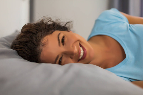 Close up portrait of beautiful woman waking up in her bed. - Foto, Imagen