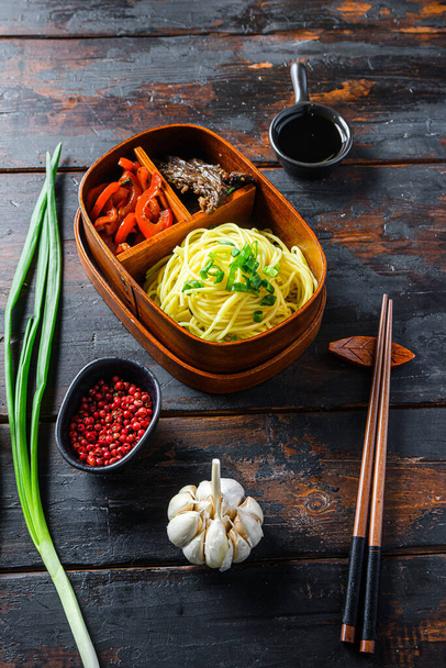 Σπιτικό Bento πακέτο μεσημεριανό γεύμα, ψητό μοσχάρι και noodles με υλικά πλευρά άποψη σκούρο ξύλινο τραπέζι. - Φωτογραφία, εικόνα