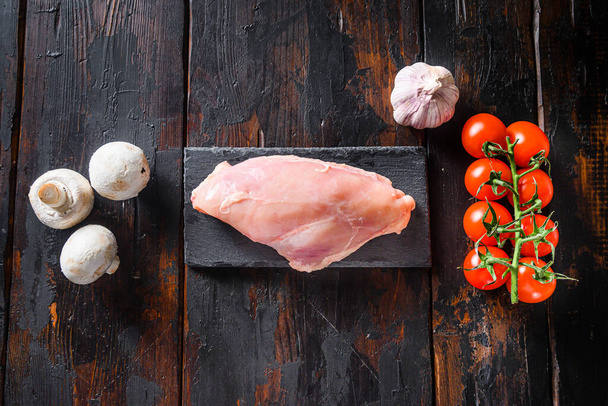  Raw organic chicken breast with meat butcher cleaver on a grey background. Food preparation, top view - Photo, Image