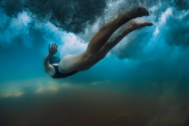 Femme plonger sans planche de surf sous les vagues de l'océan. Plongée sous-marine sous la vague et fond sablonneux - Photo, image