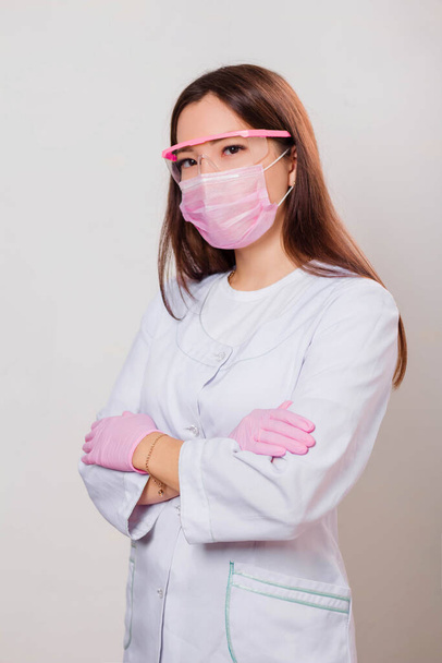 Portrait of a womanl in a white coat, mask and glasses. Photo on a white background. - Fotografie, Obrázek