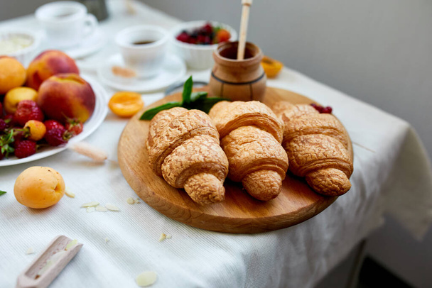 Mesa de pequeno-almoço continental servida com croissant francês tradicional, frutas e café, espaço de cópia, quadro. - Foto, Imagem