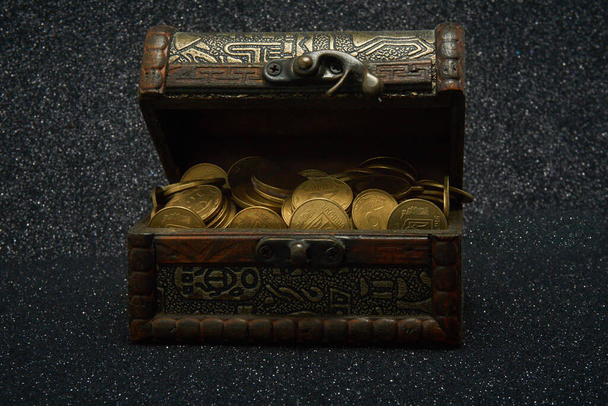 Сундук с монетами на темном фоне
 - Фото, изображение