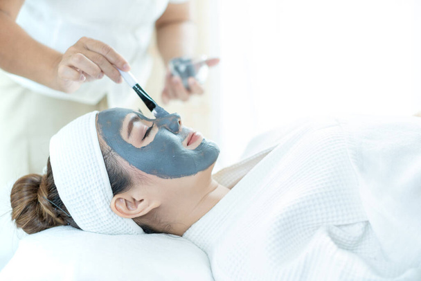 Cuidado de la piel facial. Una mujer asiática se enmascara la cara en un salón de spa. Mujer con máscara facial de spa cosmético. Tailandia
. - Foto, imagen