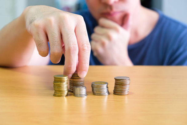 Selective focus of Asian men hand planning and put coin in stack. Personal financial or saving management concept, Wealth and earning more income, - Photo, Image