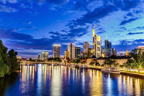 Frankfurt nad Mohanem. Panoramatická krajina evropského finančního centra. Most, řeka za soumraku, modrá hodina, západ slunce večer, noc. Zlatá žlutá barva. Cestování v Hesensku, Německo - Fotografie, Obrázek