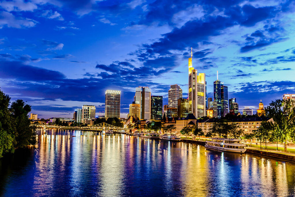 Frankfurt nad Mohanem. Panoramatická krajina evropského finančního centra. Most, řeka za soumraku, modrá hodina, západ slunce večer, noc. Zlatá žlutá barva. Cestování v Hesensku, Německo - Fotografie, Obrázek