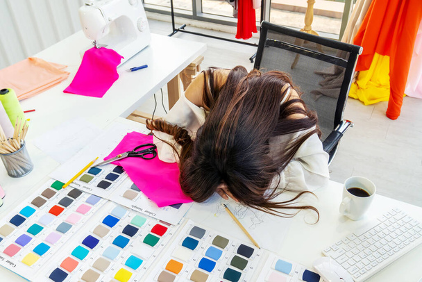 Головний біль, молода дизайнерка, яка втомилася, спить після важкої праці і втоми під час роботи в офісі, поняття розслаблення від роботи.. - Фото, зображення