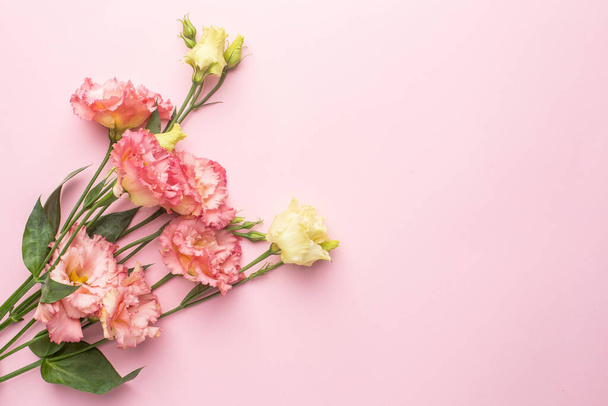 Beautiful pink flower bouquet on pastel background with copyspace top view. Holiday and love - 写真・画像
