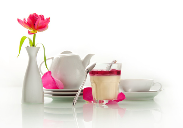 Panna cotta dessert with cherry jam with a white teapot and a tulip flower - Photo, Image