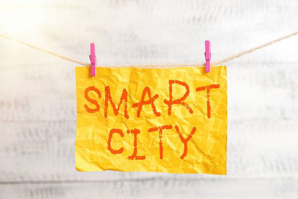 Psaný text Smart City. Obchodní koncept pro městskou oblast, která využívá komunikační technologie ke sběru dat Špendlíkový obdélníkový papírový upomínkový stůl z bílého dřeva. - Fotografie, Obrázek