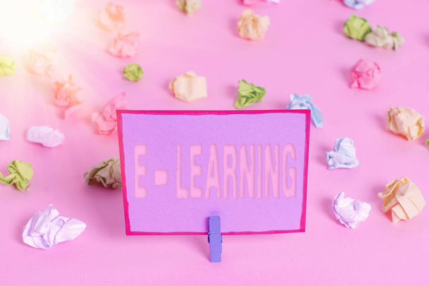Writing note showing E learning. Business photo showcasing training through electronic media usually over the internet Colored crumpled papers empty reminder pink floor background clothespin. - 写真・画像