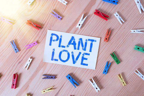 Rukopis Plant Love. Koncept znamená symbol emocionální lásky, péče a podpory ukázal ostatním barevné prádlo pin papíry prázdná připomínka dřevěné podlahy kancelář. - Fotografie, Obrázek