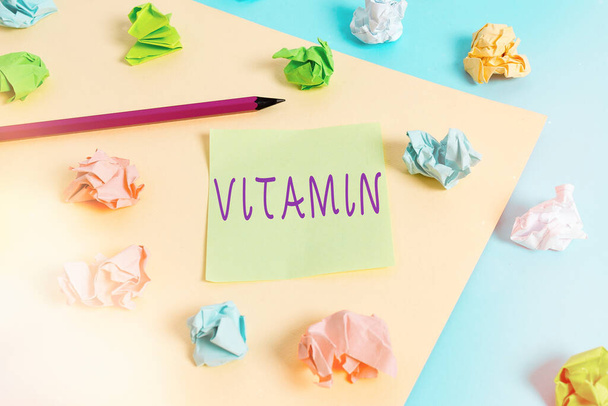 Word writing text Vitamin. Business concept for organic molecule that is essential micronutrient that organism needs Colored crumpled papers empty reminder blue yellow background clothespin. - Photo, Image