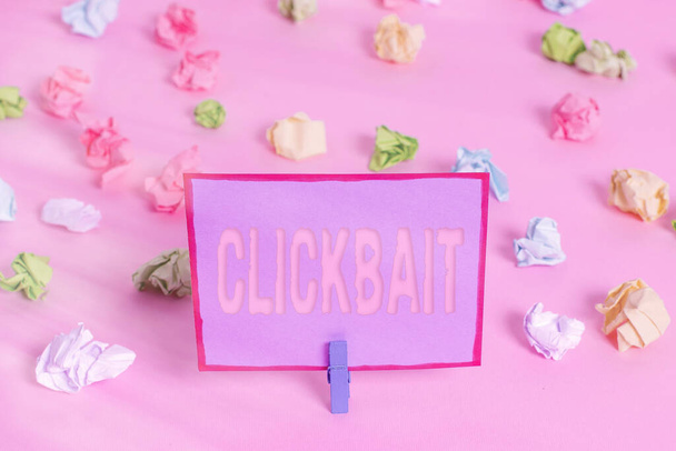Writing note showing Clickbait. Business photo showcasing the main purpose is to attract attention to a particular web page Colored crumpled papers empty reminder pink floor background clothespin. - Photo, Image