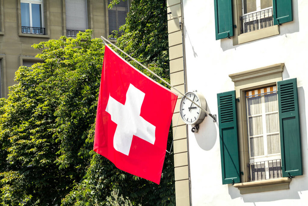 Svájci zászló lóg egy épület homlokzatán Bern, Svájc - Fotó, kép