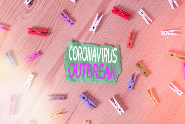 Coronavirüs salgınını gösteren kavramsal el yazısı. Yeni keşfedilen COVID19 'un sebep olduğu bulaşıcı hastalıkları gösteren iş fotoğrafı. Kırışmış kağıtlar, ahşap zemin, çamaşır mandalı.. - Fotoğraf, Görsel