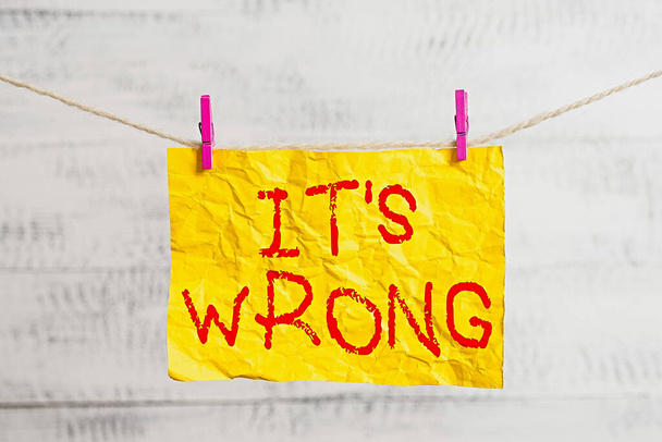 Word writing text Its Wrong. Business concept for the reaction of the wrong, unjust, improper or offending action Clothesline clothespin rectangle shaped paper reminder white wood desk. - Photo, Image