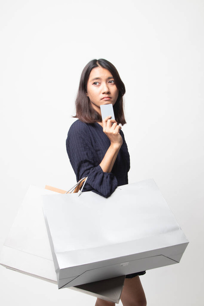 Jeune femme asiatique avec sac à provisions et carte blanche sur fond blanc
 - Photo, image