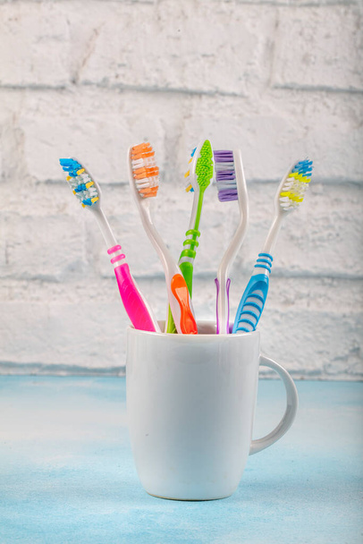 Cepillos de dientes en un soporte de cerámica. Cepillo de dientes en el estante en el baño
. - Foto, Imagen